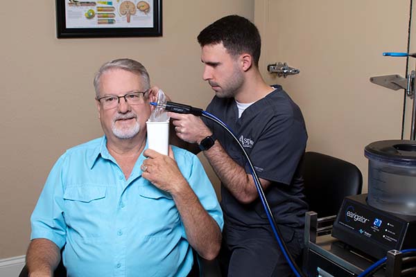 Aspire Earigator in use to remove earwax.